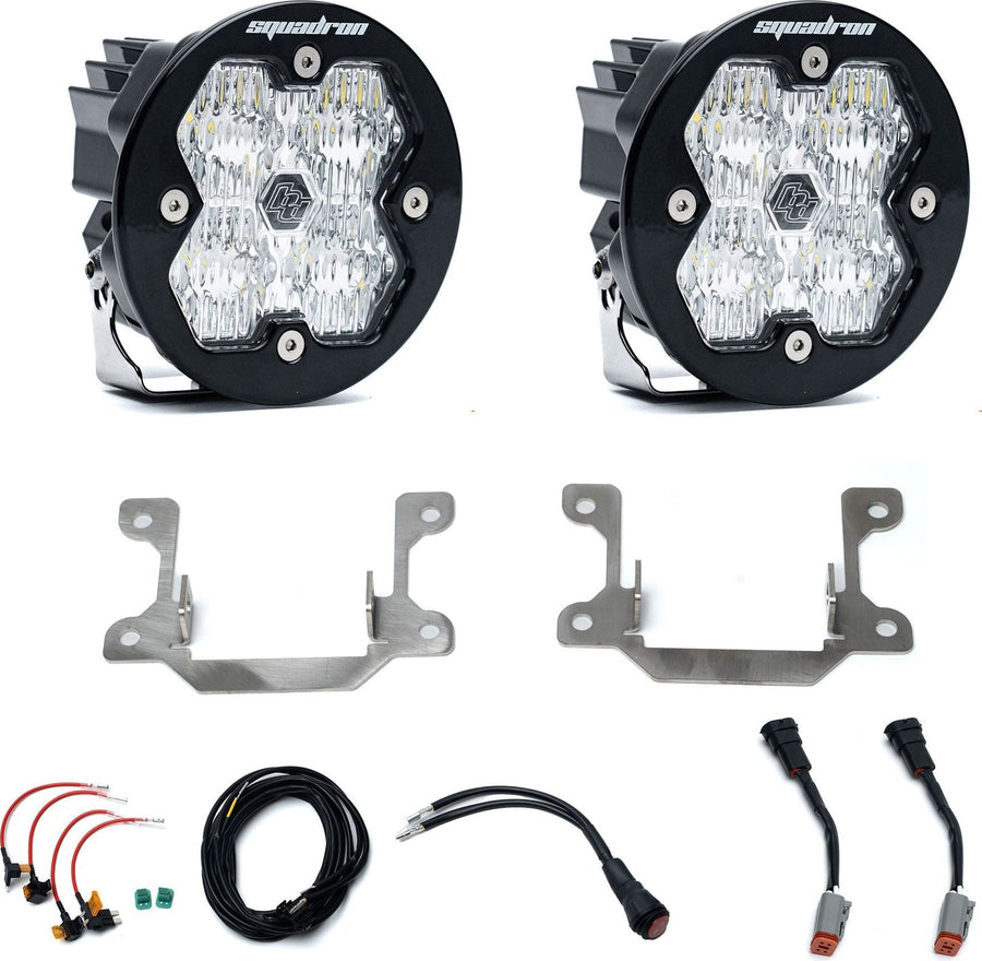 Fog Light Kits by Baja Designs: Pair of round clear lens fog lights with steel brackets, adapter harnesses and wiring on white.