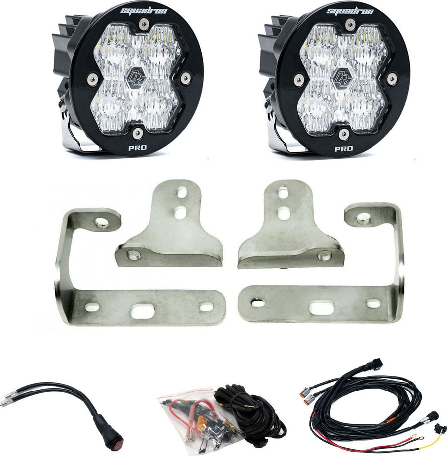 Fog Light Kits by Baja Designs: Pair of round Squadron-R Pro pods with clear lenses, stainless fog pocket brackets, wiring harness and adapters on white.