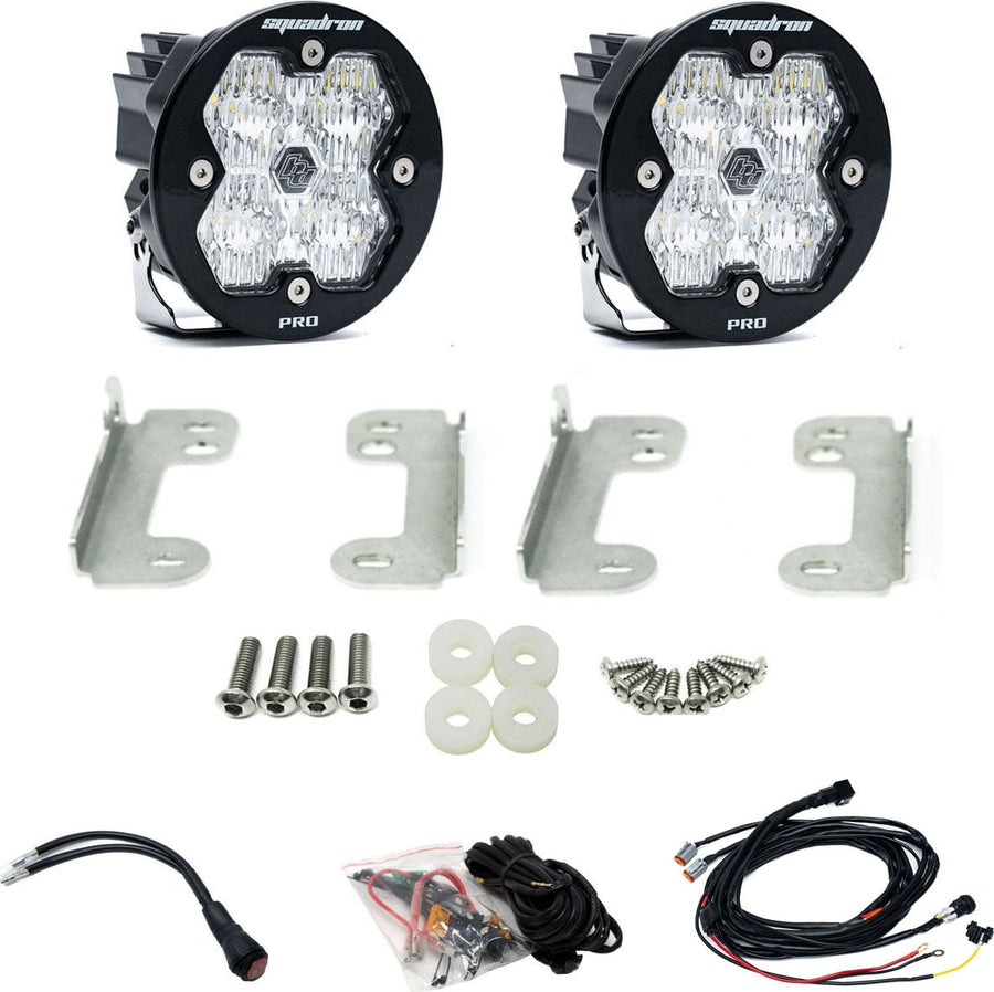Fog Light Kits by Baja Designs: Pair of round Squadron-R Pro pods with clear lenses, four stainless fog brackets, bolts, spacers and wiring harness on white.