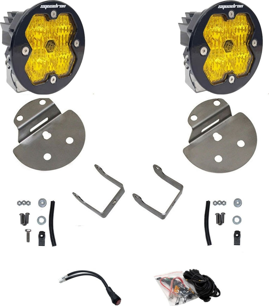 Fog Light Kits by Baja Designs: Pair of round Squadron-R pods with amber lenses, stainless round fog brackets, hardware and wiring harness on white.