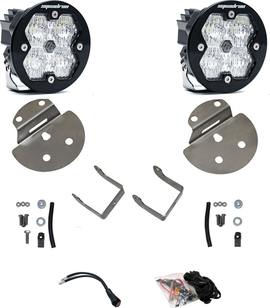 Fog Light Kits by Baja Designs: Pair of round Squadron-R pods with clear lenses, stainless round fog brackets, hardware and wiring harness on white.