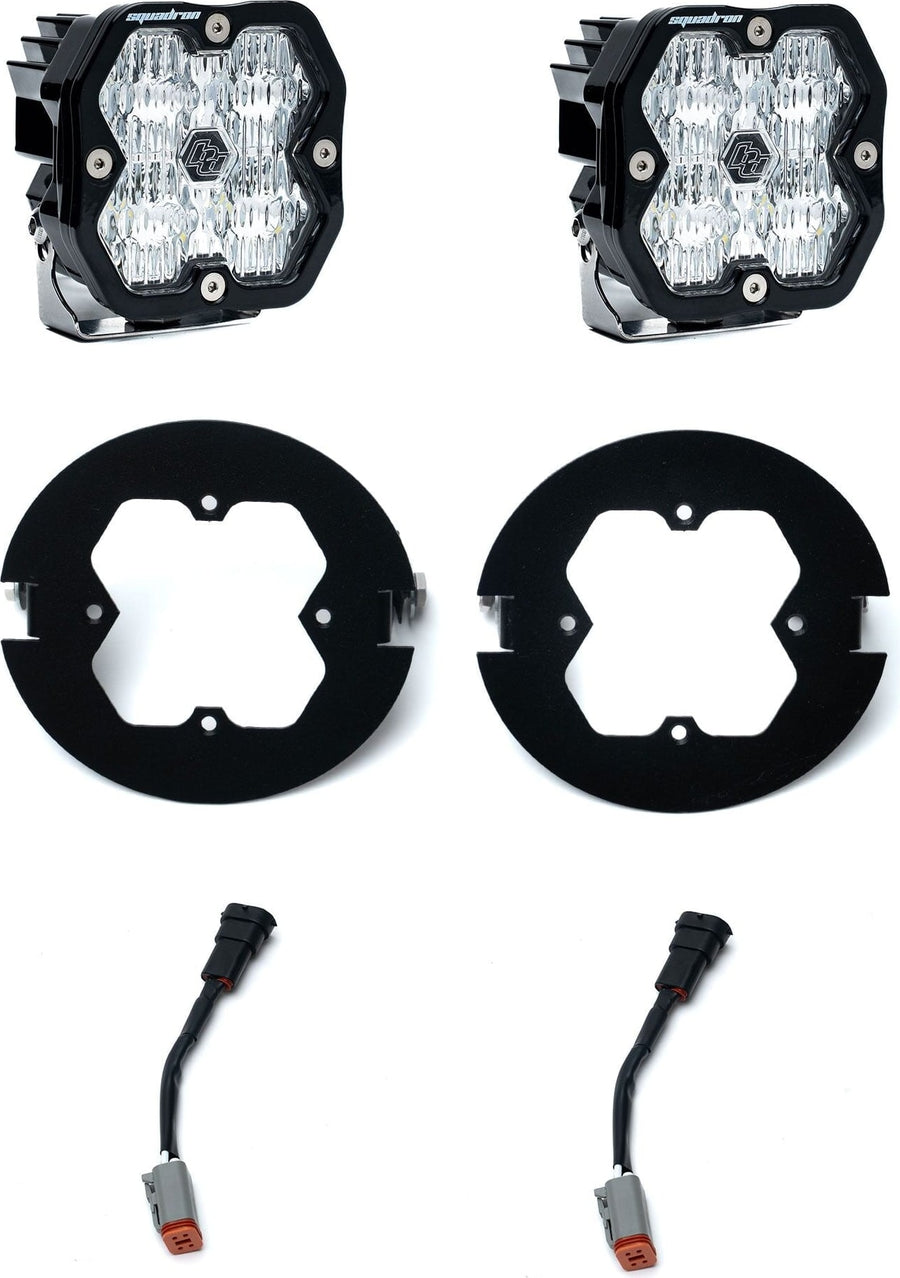 Fog Light Kits by Baja Designs: Pair of square Squadron pods with clear lenses, two black round fog adapter rings and wiring adapters on white.