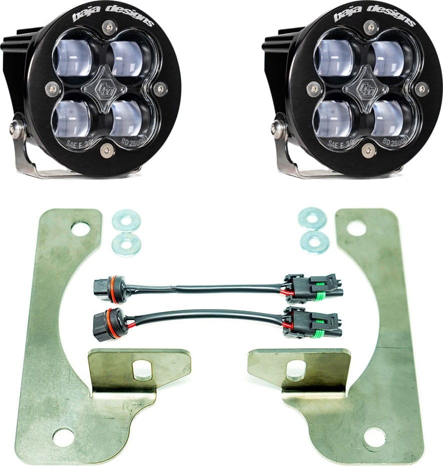 Fog Light Kits by Baja Designs: Pair of round Squadron-R fog pods with clear lenses, two large flat steel brackets, washers and two adapter harnesses on white.