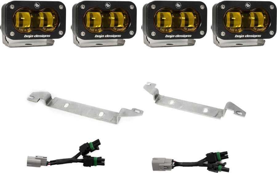Fog Light Kits by Baja Designs: Four black S2 SAE fog pods with amber lenses, two silver bumper brackets and two Y harnesses with gray factory plugs on white.