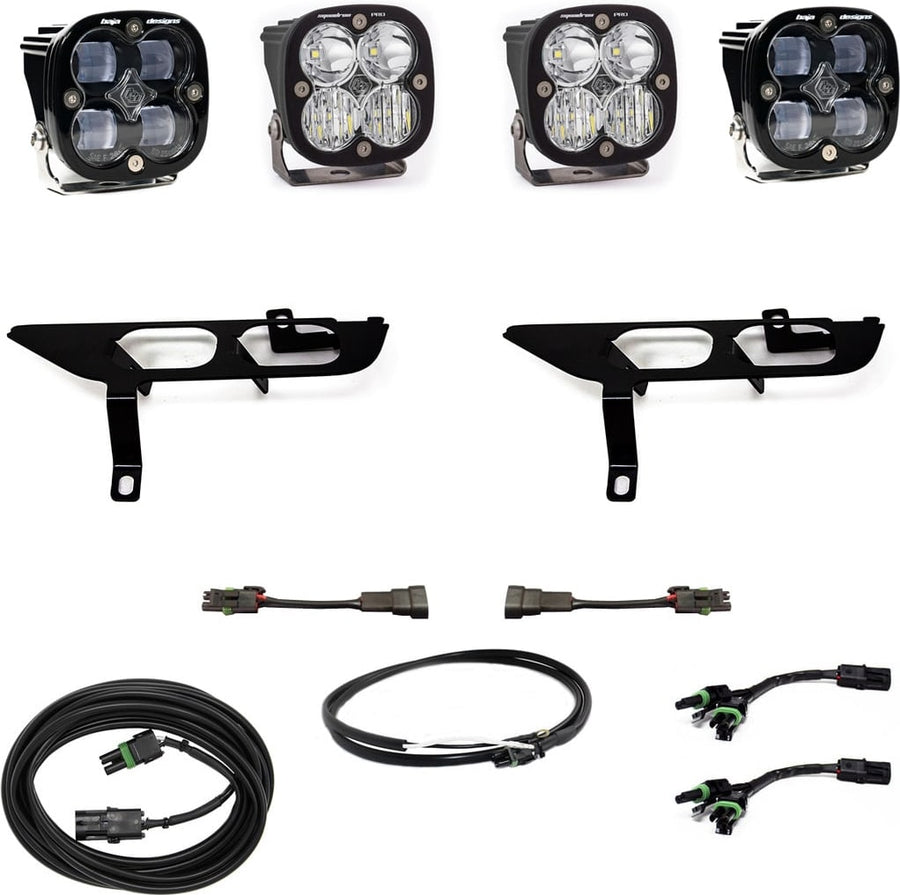 Fog Light Kits by Baja Designs: Four black Squadron pods with clear lenses, two black fog pocket brackets, adapter harnesses and coiled cables on white.