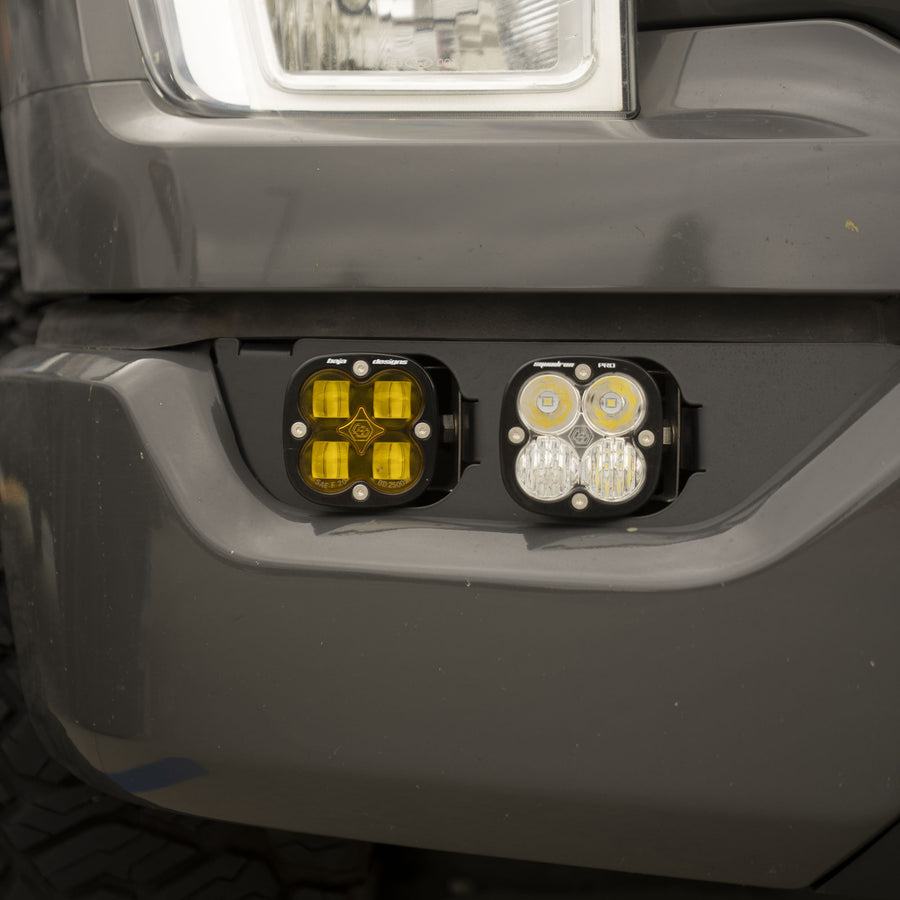 Fog Light Kits by Baja Designs: Close view of a gray truck front bumper with an amber pod and a clear pod mounted side by side in the fog pocket below the headlight.