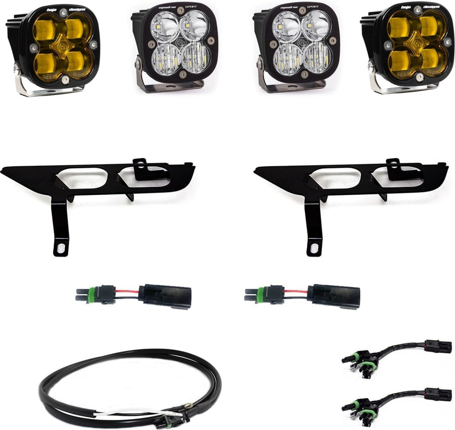 Fog Light Kits by Baja Designs: Four square Squadron pods, two black fog pocket brackets, pigtail adapters and harness, two amber and two clear lenses laid out on a white background.