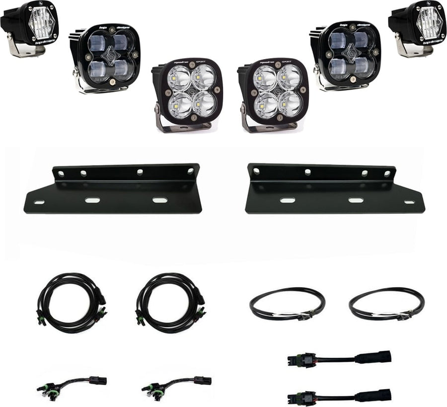 Fog Light Kits by Baja Designs: Two S1 pods and four black Squadron pods with clear lenses, two black mounting brackets, wiring harnesses and adapters on white.