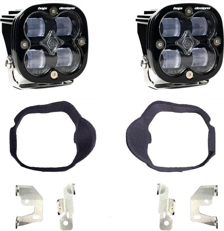 Fog Light Kits by Baja Designs: Pair of black Squadron SAE pods with clear lenses, two black fog pocket gaskets and four steel brackets on white.