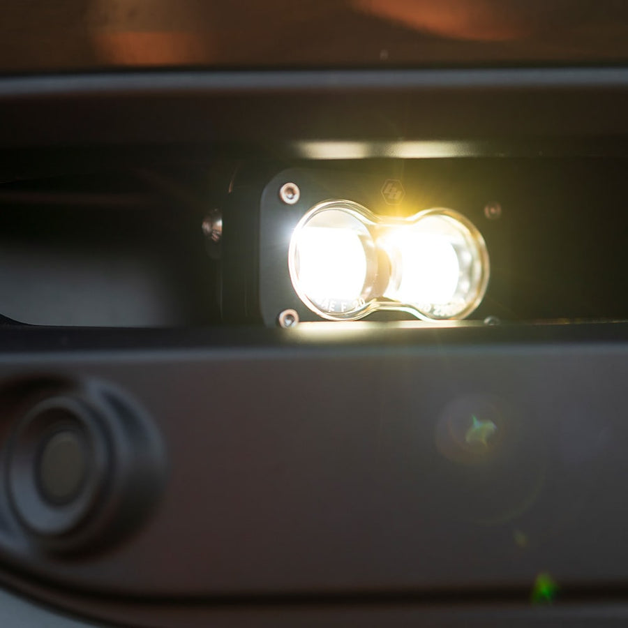 Fog Light Kits by Baja Designs: Close view of a lit S2 pod glowing in a dark bumper fog pocket.