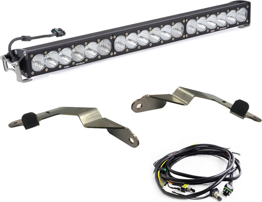 Grille Light Kits by Baja Designs: An OnX6+ 30-inch light bar with two bent steel mounting brackets and a wiring harness on white.