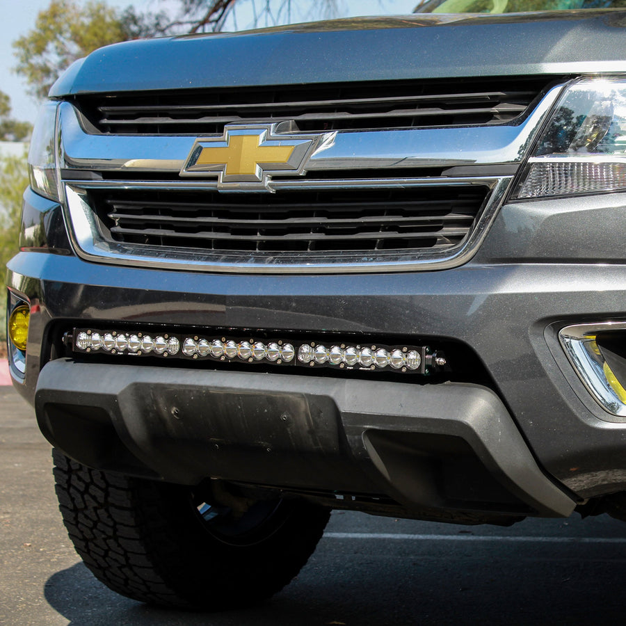 Grille Light Kits by Baja Designs: Gray Chevrolet Colorado with a long LED light bar mounted in the lower bumper opening below the gold bowtie.