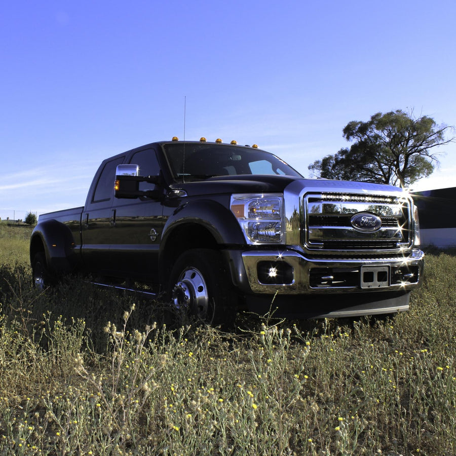 Grille Light Kits by Baja Designs: Black Ford Super Duty dually parked in a grassy field with an LED light bar in the upper grille.