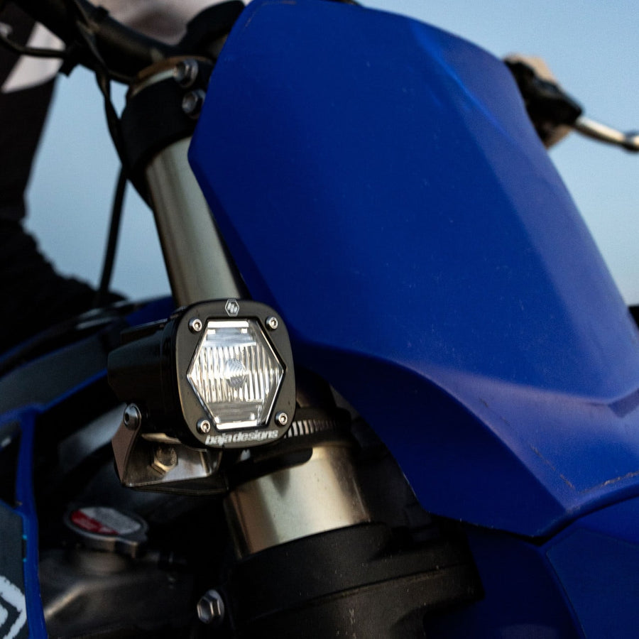 Lens Kits & Covers by Baja Designs: S1 pod with a clear lens mounted on the fork of a blue dirt bike.
