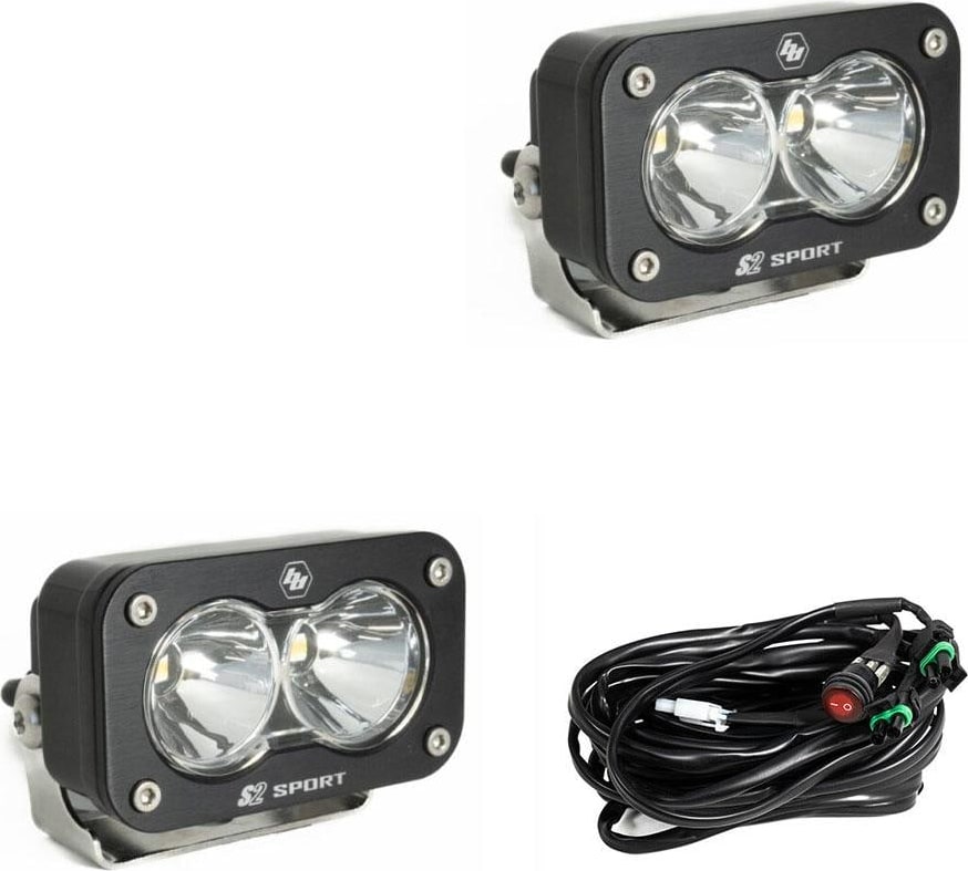 S2 Light Pods by Baja Designs: Pair of black S2 Sport light pods with clear spot reflectors, brackets and a wiring harness on a white background.