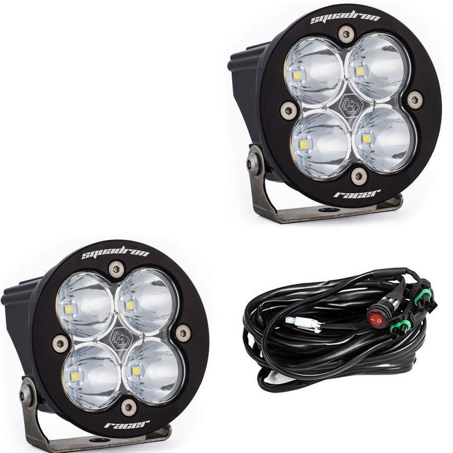 Squadron Light Pods by Baja Designs: Two round black Squadron-R Racer Edition pods with clear lenses and a wiring harness on a white background.