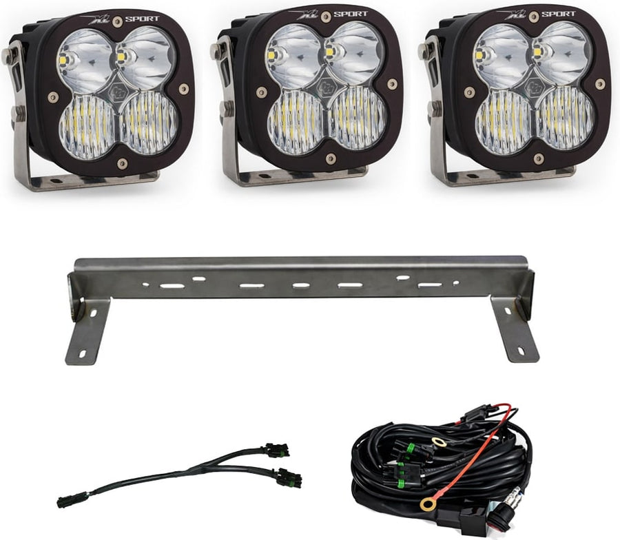 Bumper Light Kits by Baja Designs: Three XL Sport LED pods with clear lenses, a steel bumper mounting bar and wiring harnesses on a white background.