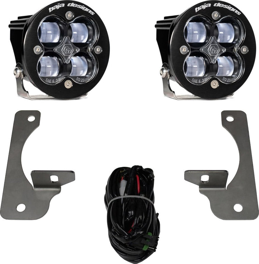 Fog Light Kits by Baja Designs: A pair of black Squadron-R pods with clear lenses shown with two fog pocket brackets and a wiring harness on white.