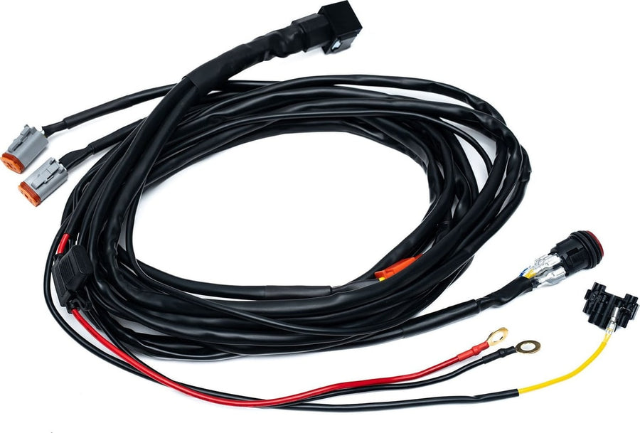 Wiring Harnesses by Baja Designs: A two light wiring harness with two gray Deutsch connectors, a round switch and power leads on white.