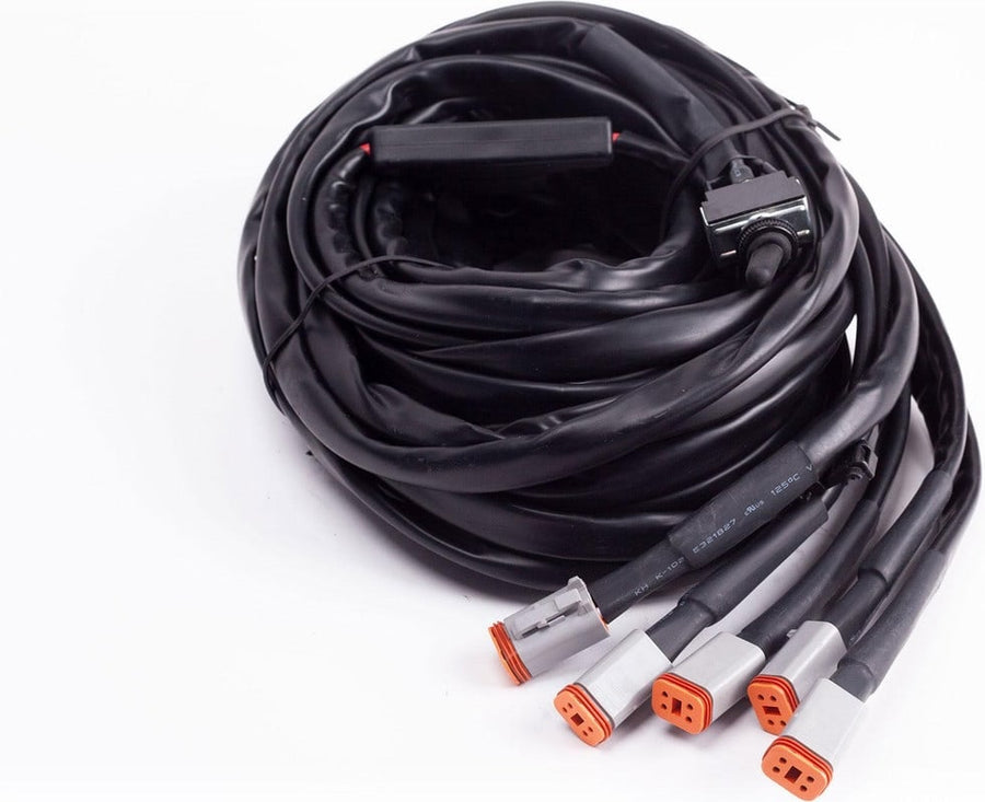 Wiring Harnesses by Baja Designs: A coiled wiring harness with five gray Deutsch connectors and a switch on white.