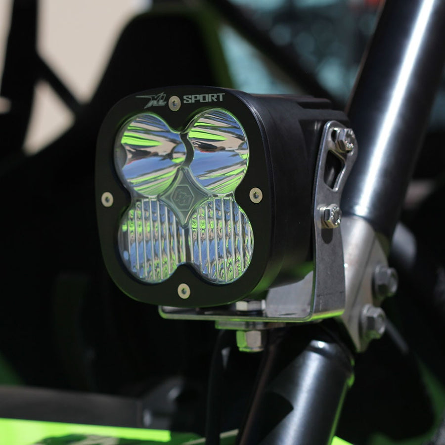 XL Light Pods by Baja Designs: A black Baja Designs XL Sport LED pod with a clear lens clamped to the roll cage tube of a green side-by-side.