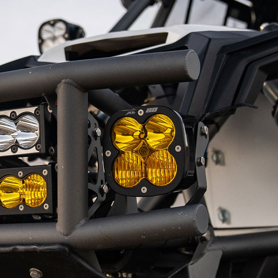 XL Light Pods by Baja Designs: A black Baja Designs XL80 LED pod with an amber lens mounted on the tube front bumper of a side-by-side next to smaller light bars.