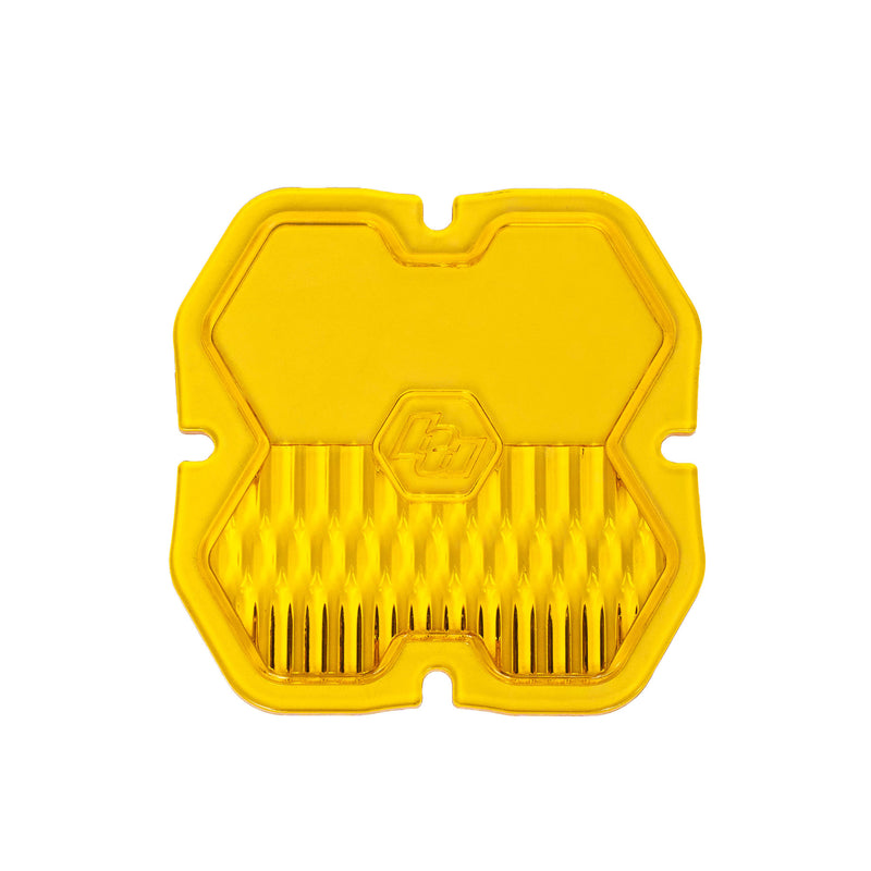 Baja Designs Squadron 2.0 Light Pod Lens Kit, complete kit on a studio background: A yellow Baja Amber Squadron pod lens with a combo optic pattern and a molded Baja Designs logo, shown flat on a white background