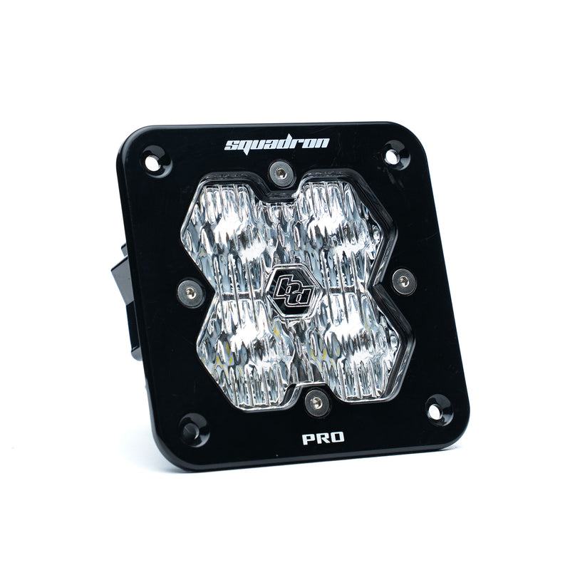 Baja Designs Squadron 2.0 Pro Black Flush Mount LED Auxiliary Light Pod, whole product on a studio background: A black Baja Designs Squadron Pro flush mount LED pod with a clear wide cornering lens on a white background