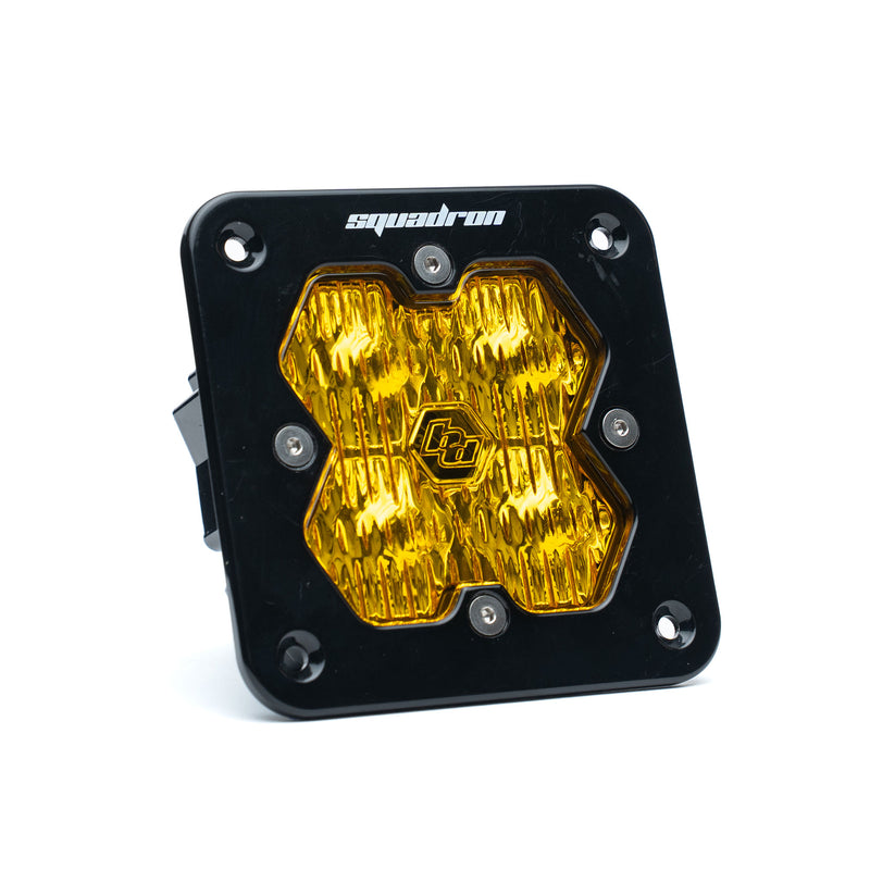 Baja Designs Squadron 2.0 Sport Black Flush Mount LED Auxiliary Light Pod, whole product on a studio background: A black Baja Designs Squadron Pro flush mount LED pod with an amber driving/combo lens on a white background