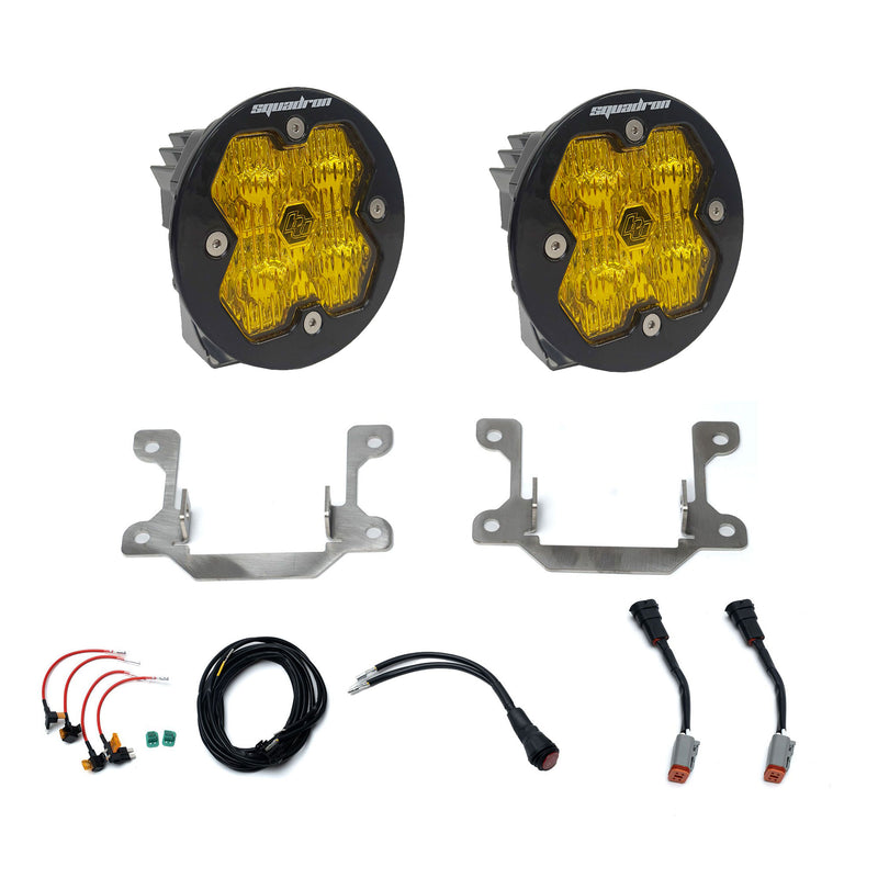 Baja Designs Squadron 2.0 Sport Fog Pocket Light Kit, complete kit on a studio background: pair of round amber lens fog lights with steel brackets, adapter harnesses and wiring on white