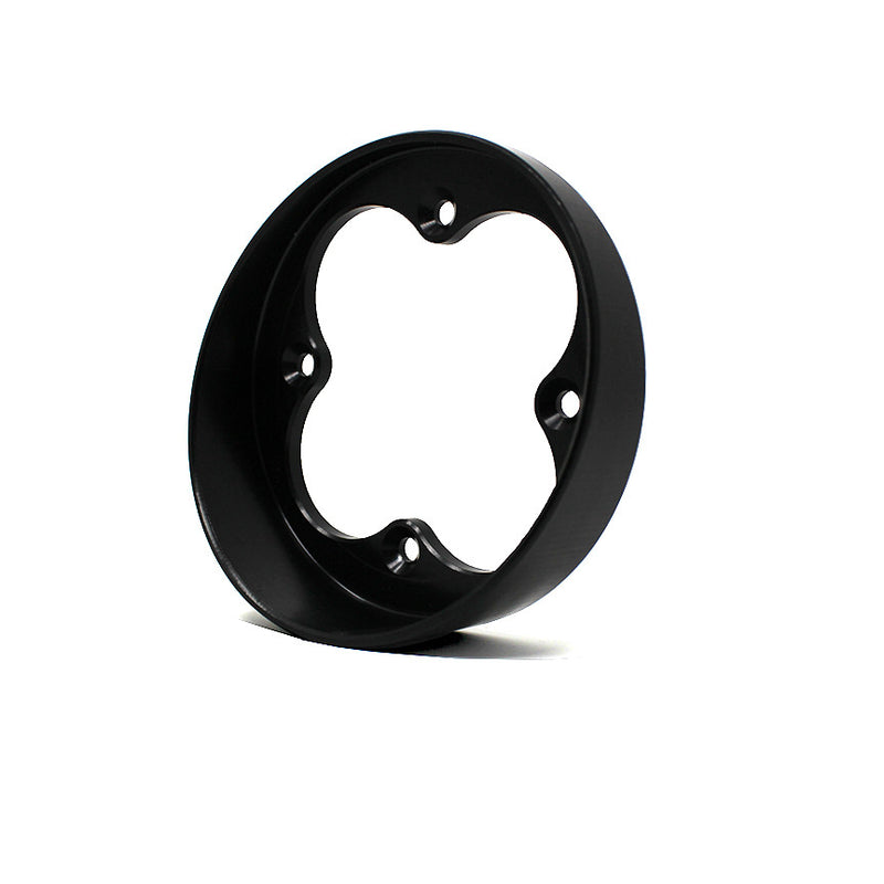 Baja Designs Squadron Angled Bezel, whole product on a studio background: A black round angled bezel with a four-lobe Squadron opening shown from a lower angle on a white background
