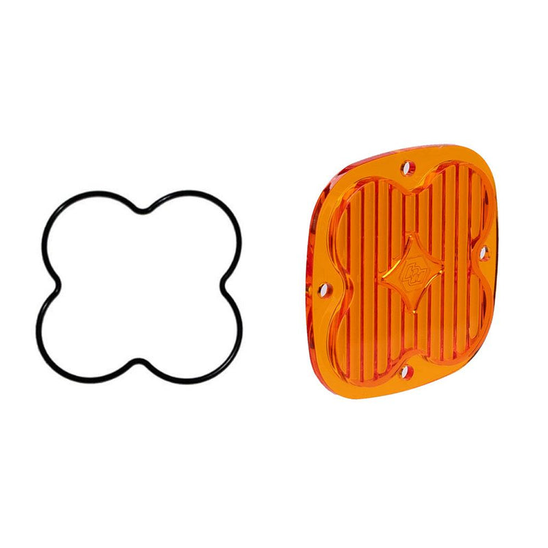 Baja Designs Squadron Light Pod Lens Kit, complete kit on a studio background: A orange-amber rounded-square Squadron replacement lens with a fully fluted wide cornering optic lies beside its black O-ring gasket on a white background