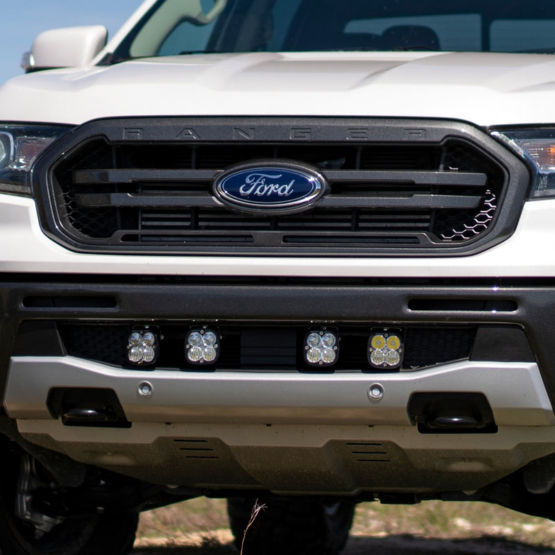 Baja Designs Squadron Pro Grille Light Kit on a Ford Ranger: front view of a white Ford Ranger with four square pods mounted across the lower grille