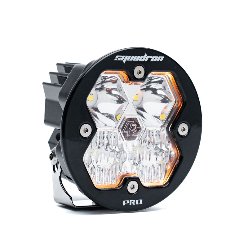 Baja Designs Squadron-R 2.0 Pro Black LED Auxiliary Light Pod, whole product on a studio background: A round black Squadron-R Pro LED pod with a clear spot lens and amber accent trim on a white background