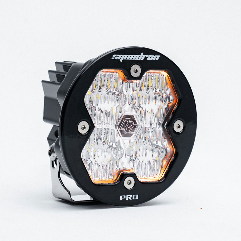 Baja Designs Squadron-R 2.0 Pro Black LED Auxiliary Light Pod, whole product on a studio background: A round black Squadron-R Pro LED pod with a clear fluted lens on a light gray background