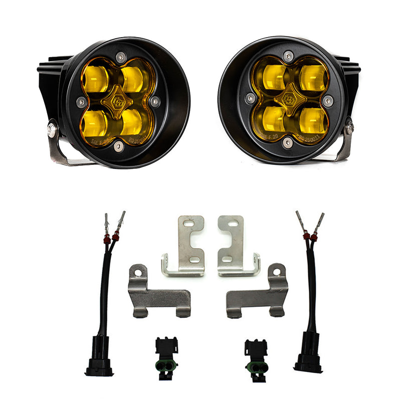 Baja Designs Squadron-R SAE Fog Pocket Light Kit, complete kit on a studio background: pair of round black Squadron-R SAE fog pods with amber lenses above four bare steel brackets, two pigtail harnesses and two connectors on white