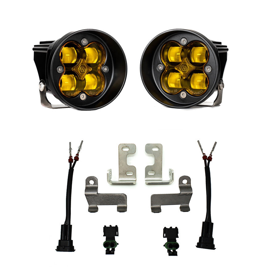 Baja Designs Squadron-R SAE Fog Pocket Light Kit, complete kit on a studio background: pair of round Squadron-R pods with steel brackets, two pigtail harnesses and connectors, amber lenses laid out on a white background. Lens color differs from the