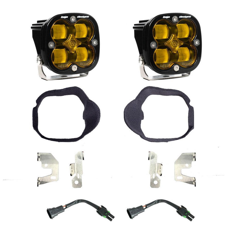 Baja Designs Squadron SAE Fog Pocket Light Kit, complete kit on a studio background: pair of square Squadron pods with fabric-wrapped fog bezel rings, steel brackets and two pigtail harnesses, amber lenses laid out on a white background. Lens color