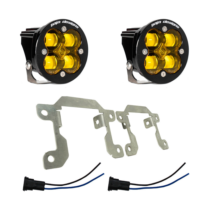 Baja Designs Squadron SAE Fog Pocket Light Kit, complete kit on a studio background: two round black Squadron SAE fog pods with amber lenses, two silver mounting brackets and two pigtail harnesses on white; amber shown while this frame is tied only