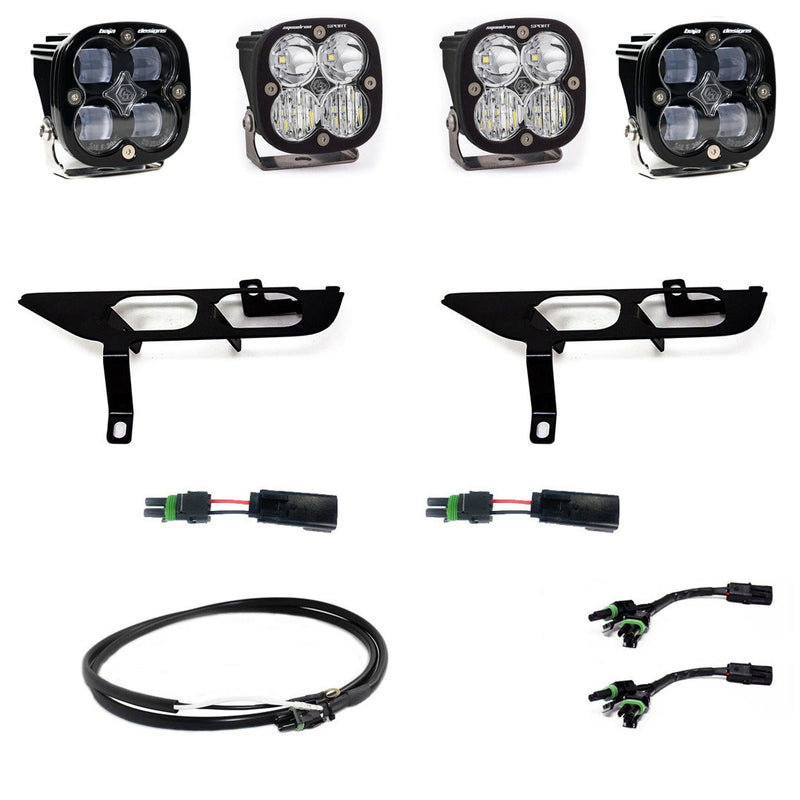 Baja Designs Squadron SAE/Sport Fog Pocket Light Kit, complete kit on a studio background: four square Squadron pods, two black fog pocket brackets, pigtail adapters and harness, all clear lenses laid out on a white background. Lens color differs