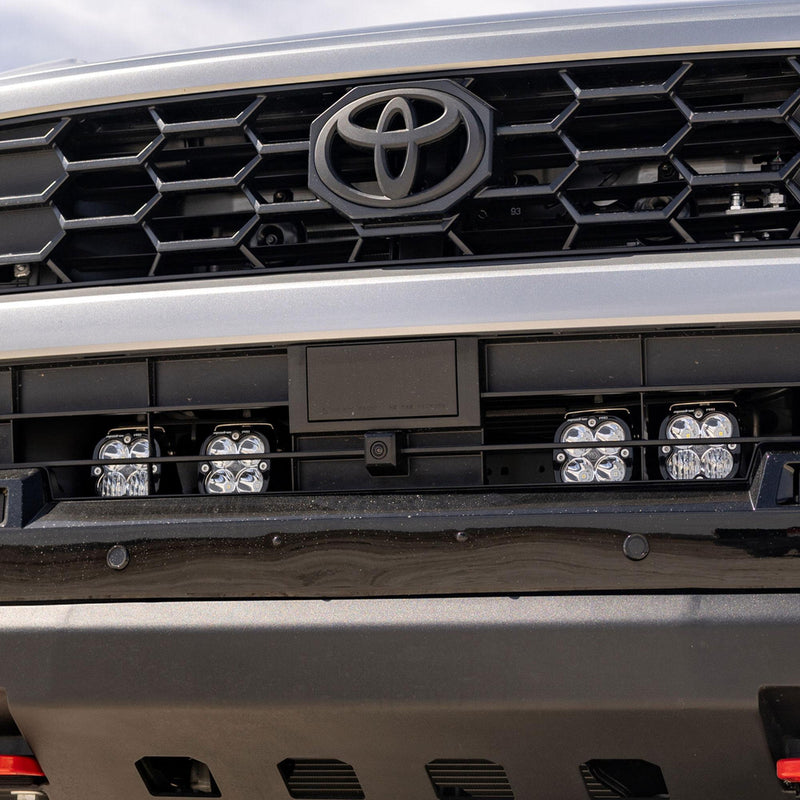 Baja Designs Squadron Sport Behind-the-Grille Kit on a Toyota 4Runner: four square LED pods mounted behind the lower grille of a silver Toyota 4Runner