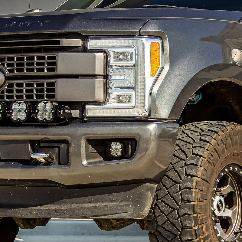 Baja Designs Squadron Sport Fog Pocket Light Kit on a Ford F-250/F-350 Super Duty: close view of a gray Ford Super Duty front corner with a Squadron Sport pod in the bumper fog pocket and more pods above