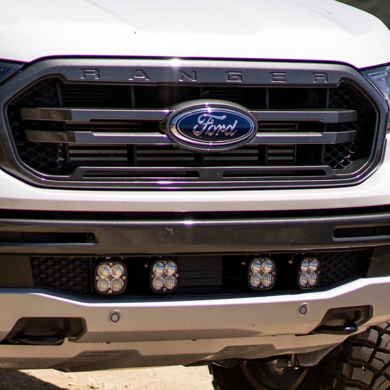 Baja Designs Squadron Sport Grille Light Kit on a Ford Ranger: close view of a white Ford Ranger front end with four square pods mounted in the lower grille
