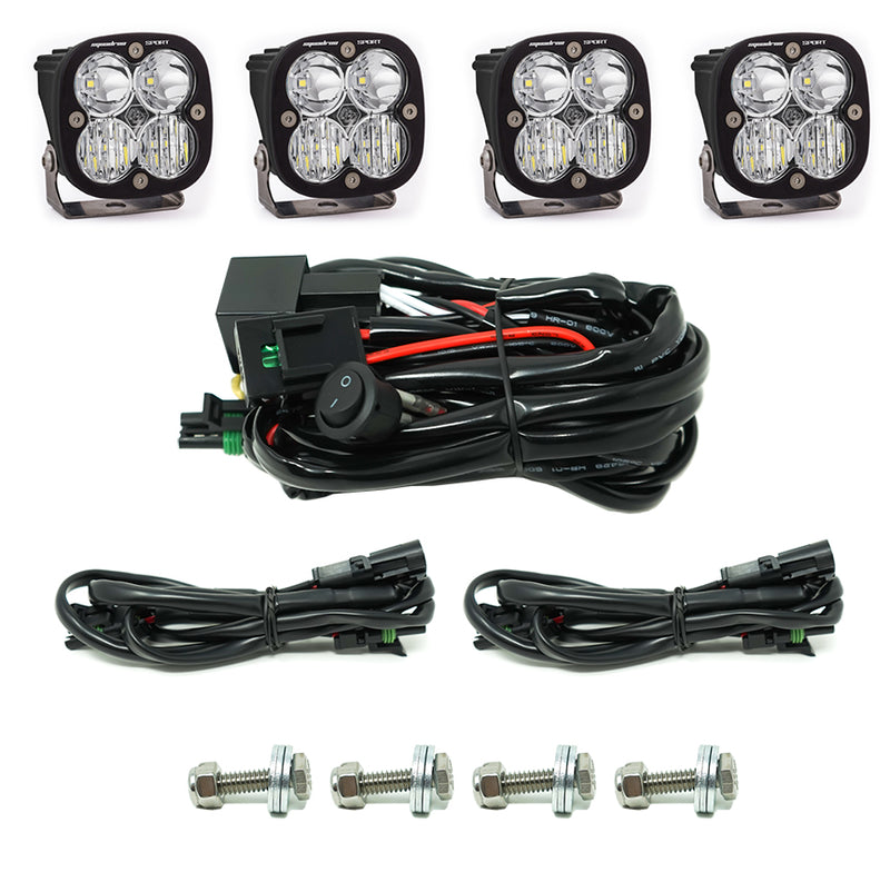 Baja Designs Squadron Sport Grille Light Kit, complete kit on a studio background: four Squadron Sport pods with clear lenses, a switch harness, two extension harnesses and four mounting bolts on white