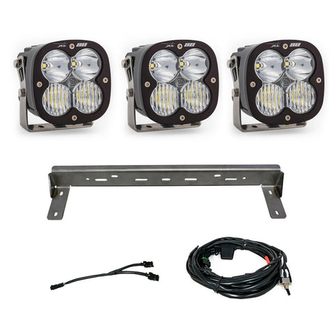 Baja Designs XL 80 Bumper Kit, complete kit on a studio background: three XL80 LED pods with clear lenses, a steel bumper mounting bar and wiring harnesses on a white background