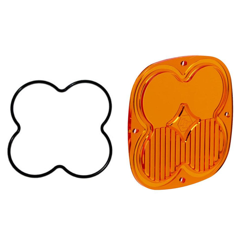 Baja Designs XL Light Pod Lens Kit, complete kit on a studio background: A orange-amber rounded-square XL replacement lens with a half-fluted driving/combo optic lies beside its black O-ring gasket on a white background