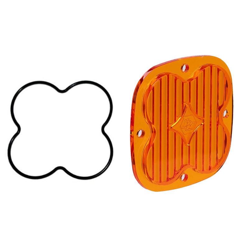 Baja Designs XL Light Pod Lens Kit, complete kit on a studio background: an orange amber XL pod lens with a fluted face beside a black clover shaped gasket, angled on a white background. Title gives no lens color and this SKU shows several colors, so