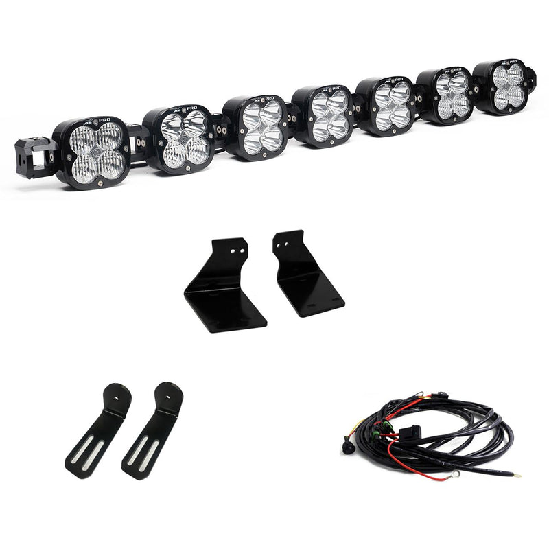 Baja Designs XL Linkable Bumper Light Kit, complete kit on a studio background: A seven-pod XL Linkable light bar kit on white with two bumper brackets, two slotted mounts and a relay wiring harness