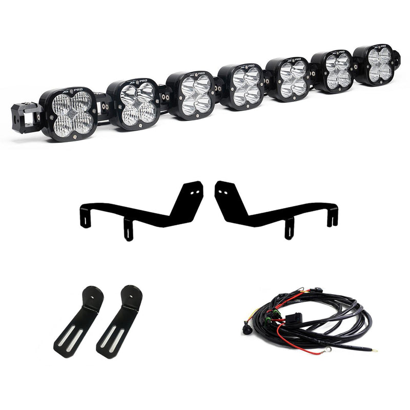 Baja Designs XL Linkable Bumper Light Kit, complete kit on a studio background: A seven-pod XL Linkable light bar kit on white with two bumper brackets, two slotted mounts and a relay wiring harness