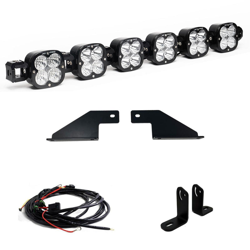 Baja Designs XL Linkable Bumper Light Kit, complete kit on a studio background: A six-pod XL Linkable light bar kit on white with two flat bumper brackets, two L-brackets and a relay wiring harness